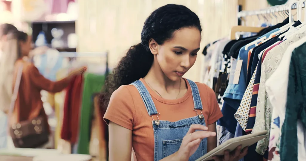 Dona de loja de roupas consultando no tablet os resultados dos anúncios da empresa
