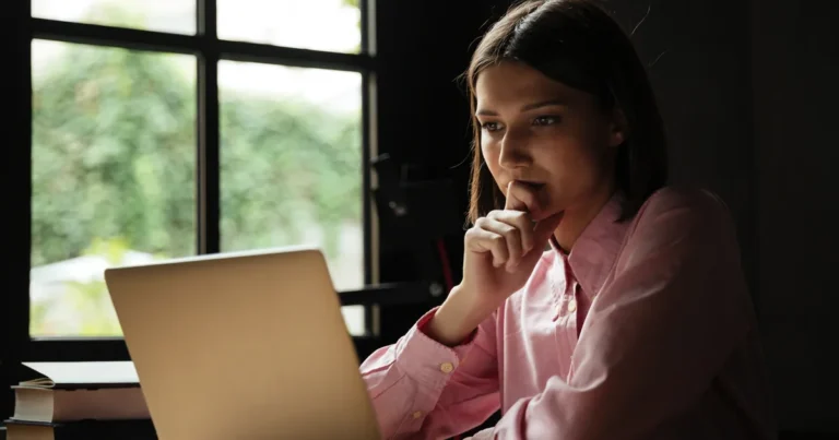 Empreendedora pensativa diante do notebook, tentando entender por que sua empresa não aparece no Google